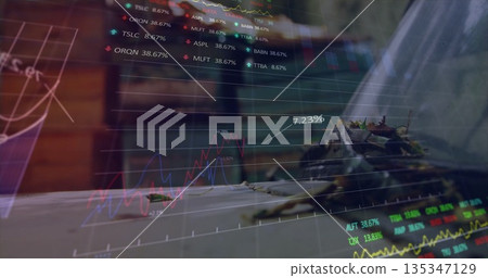Overlaying financial line graph on wooden desk, with succulent plant and closed laptop Overlaying financial line graph on wooden desk, with succulent plant and closed laptop 135347129