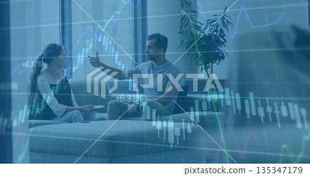 Discussing two office workers analyzing stock chart in modern office lounge, with tablet and plant Discussing two office workers analyzing stock chart in modern office lounge, with tablet and plant 135347179