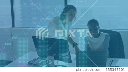 Mid-adult women collaborating in corporate office, with laptop desktop monitor and financial charts Mid-adult women collaborating in corporate office, with laptop desktop monitor and financial charts 135347201