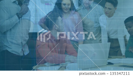 Collaborating business professionals reviewing projected graph in modern meeting room, with laptop 135347211