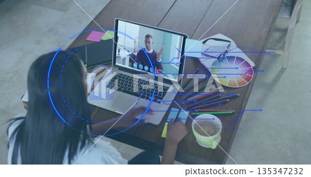 Woman in blouse joining conference on laptop in studio, with color wheel, coffee mug, copy space 135347232