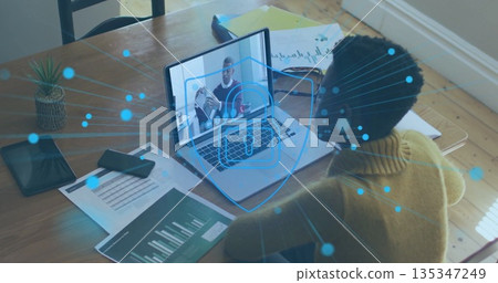 Analyzing woman in yellow top watching coworker on laptop in study with security icon, copy space Analyzing woman in yellow top watching coworker on laptop in study with security icon, copy space 135347249