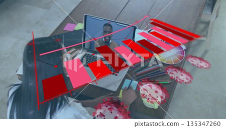 Taking notes woman in blouse holding pen at office table, with laptop displaying chart, virus data Taking notes woman in blouse holding pen at office table, with laptop displaying chart, virus data 135347260