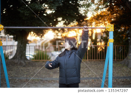 High school girls having fun playing in a park in a residential area on a winter evening 135347297