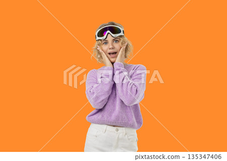 Blonde woman in ski goggles and a purple sweater Blonde woman in ski goggles and a purple sweater 135347406