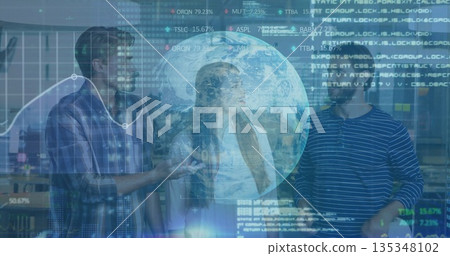 Gesturing tech team examining financial overlays in modern office, holographic globe projection 135348102