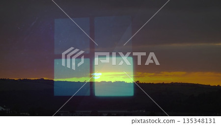 Reflecting four-pane digital grid through glass window over hills at sunset, with hill silhouettes 135348131