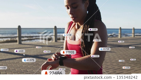 Checking runner in sportswear tracking metrics on sea walkway with watch and icons, copy space 135348242