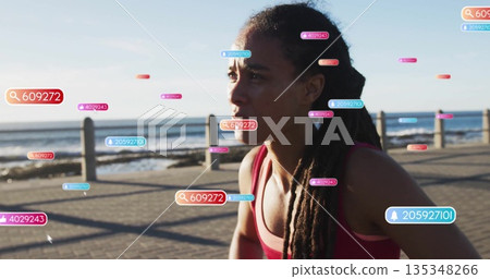 Woman running in red sports bra along seaside path by railing, with digital overlays, copy space 135348266