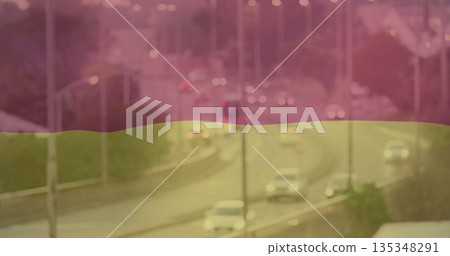 Curving highway carrying passenger cars traveling on wet urban overpass at dusk, with streetlights Curving highway carrying passenger cars traveling on wet urban overpass at dusk, with streetlights 135348291