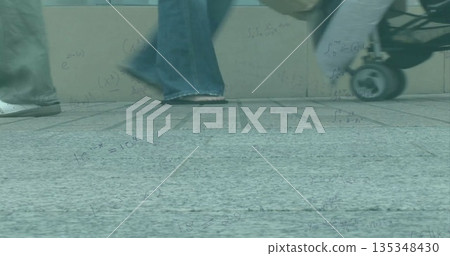 Walking adult in jeans on tiled pavement next to stone barrier with stroller wheel, math formulas 135348430