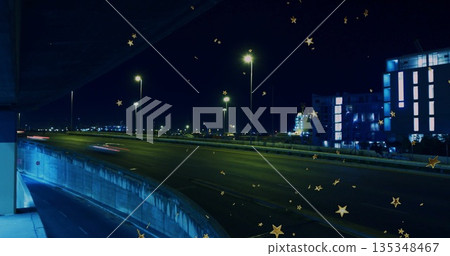 Stretching highway curving left at night by streetlights, with barrier, light trails, golden stars Stretching highway curving left at night by streetlights, with barrier, light trails, golden stars 135348467