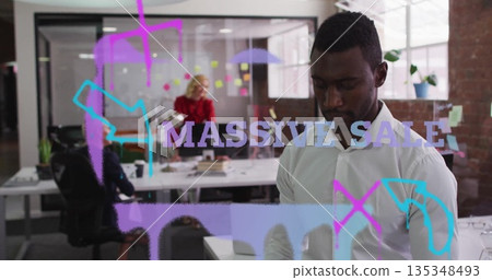 Standing man in white shirt reviewing notes on device in open office, with glass partition sketches 135348493