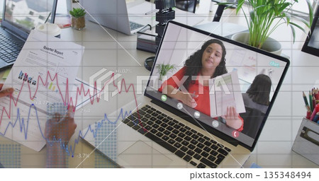 Showing laptop screen with woman in red blouse presenting quarter report at office desk, with pen 135348494