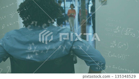 Pushing man in wheelchair down corridor, equations floating, coworker reading tablet, copy space Pushing man in wheelchair down corridor, equations floating, coworker reading tablet, copy space 135348529