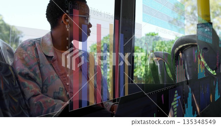 Analyzing woman in print jacket glasses reviewing laptop at bus window with AR overlay, copy space 135348549