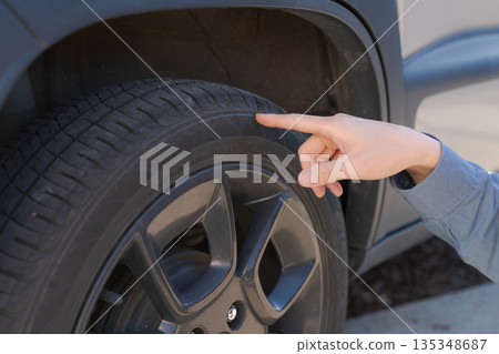 Man pointing at tire 135348687