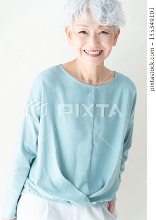 一位老婦人站在牆前 135349101