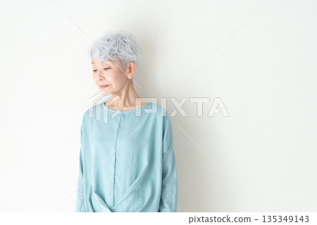 Senior woman standing in front of a wall Senior woman standing in front of a wall 135349143