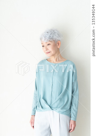 Senior woman standing in front of a wall Senior woman standing in front of a wall 135349144