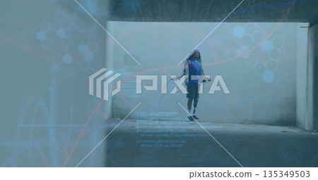 Jumping man wearing sleeveless hooded sweatshirt and shorts in concrete underpass, with jump rope Jumping man wearing sleeveless hooded sweatshirt and shorts in concrete underpass, with jump rope 135349503