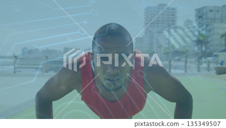 Doing push-ups adult man wearing red athletic top on seaside promenade, with green mat and earbuds Doing push-ups adult man wearing red athletic top on seaside promenade, with green mat and earbuds 135349507