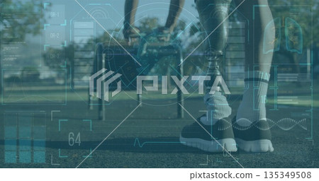 Standing mid-adult man showing prosthetic limb on park track, with metal bars and interface overlay Standing mid-adult man showing prosthetic limb on park track, with metal bars and interface overlay 135349508