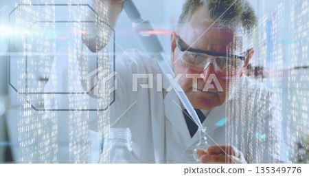 Senior male scientist dispensing into flask at lab bench using pipette, with vials and data overlay Senior male scientist dispensing into flask at lab bench using pipette, with vials and data overlay 135349776
