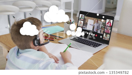 Attending online class boy wearing striped shirt, headset at home with laptop, notebook, copy space 135349782