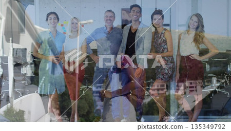 Posing six professionals in business casual smiling in conference area with glass wall and chairs 135349792