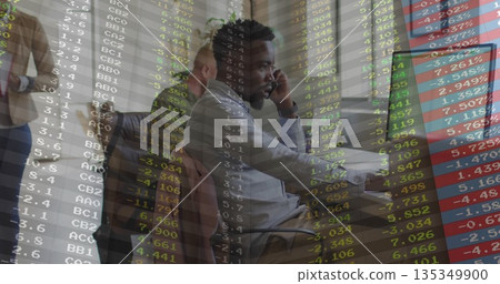 African American man speaking on smartphone with headset and using computer in office, stock data African American man speaking on smartphone with headset and using computer in office, stock data 135349900