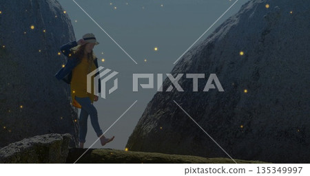 Balancing adult woman lifting foot on rocky ledge between granite boulders, with straw brimmed hat Balancing adult woman lifting foot on rocky ledge between granite boulders, with straw brimmed hat 135349997