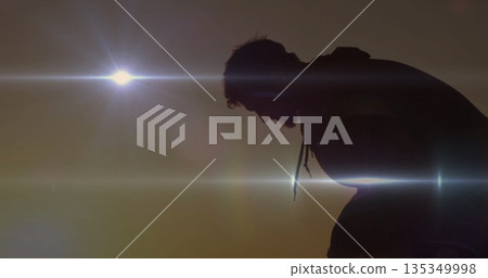 Leaning forward man silhouette wearing hoodie at outdoor sunset, with low-hanging sun, copy space Leaning forward man silhouette wearing hoodie at outdoor sunset, with low-hanging sun, copy space 135349998