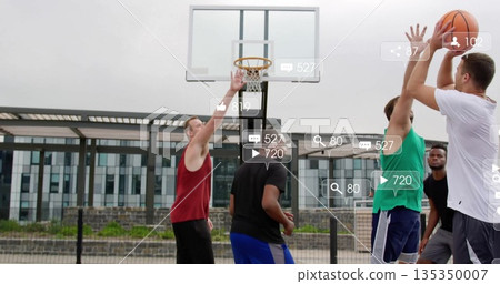 Jumping men shooting basketball at hoop on urban court by glass building, with social media icons 135350007