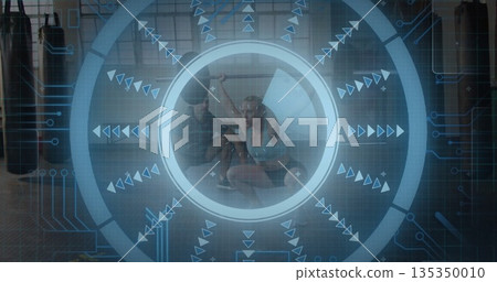 Squatting workout partners holding weight plate overhead in gym, with punching bags and AR overlay Squatting workout partners holding weight plate overhead in gym, with punching bags and AR overlay 135350010