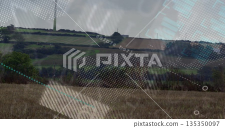 Turbine rising over meadow, hedgerow shrubs in farmland, with digital overlay patterns, copy space 135350097