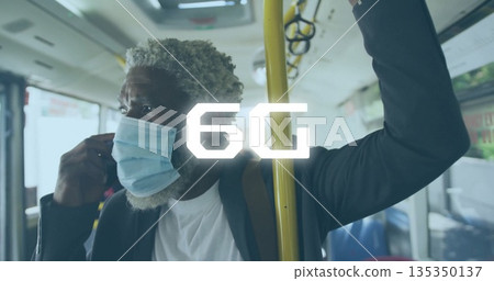 Standing commuter gripping yellow pole and adjusting mask strap on transit bus, with backpack Standing commuter gripping yellow pole and adjusting mask strap on transit bus, with backpack 135350137