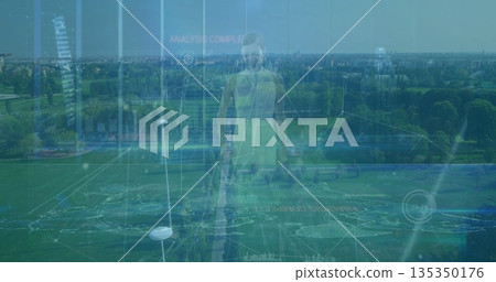 Standing woman wearing neon green sportswear at aerial park sports field markings, data panels 135350176