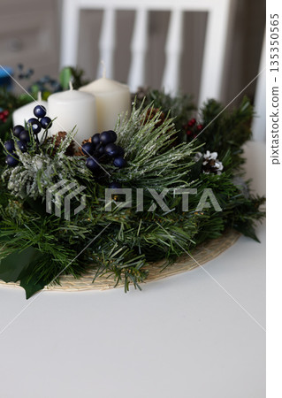 Holiday wreath on a table with candles and decorations 135350565