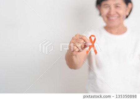 Elderly with Orange Ribbon for September Leukemia, March Kidney cancer day, Multiple Sclerosis, Self Injury Awareness month, November Complex Regional Pain Syndrome, CRPS, COPD disease concept Elderly with Orange Ribbon for September Leukemia, March Kidney cancer day, Multiple Sclerosis, Self Injury Awareness month, November Complex Regional Pain Syndrome, CRPS, COPD disease concept 135350898