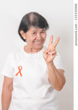 Elderly with Orange Ribbon for September Leukemia, March Kidney cancer day, Multiple Sclerosis, Self Injury Awareness month, November Complex Regional Pain Syndrome, CRPS, COPD disease concept 135350906