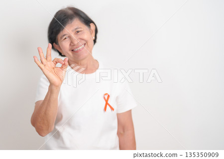 Elderly with Orange Ribbon for September Leukemia, March Kidney cancer day, Multiple Sclerosis, Self Injury Awareness month, November Complex Regional Pain Syndrome, CRPS, COPD disease concept Elderly with Orange Ribbon for September Leukemia, March Kidney cancer day, Multiple Sclerosis, Self Injury Awareness month, November Complex Regional Pain Syndrome, CRPS, COPD disease concept 135350909