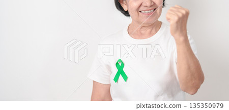 Elderly with Green Ribbon for concept of March world Bipolar disorder day, Cerebral Palsy Awareness month, kidney disease Cancer and Traumatic Brain Injury, TBI. Healthcare and world cancer day Elderly with Green Ribbon for concept of March world Bipolar disorder day, Cerebral Palsy Awareness month, kidney disease Cancer and Traumatic Brain Injury, TBI. Healthcare and world cancer day 135350979
