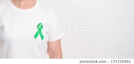 Elderly with Green Ribbon for concept of March world Bipolar disorder day, Cerebral Palsy Awareness month, kidney disease Cancer and Traumatic Brain Injury, TBI. Healthcare and world cancer day Elderly with Green Ribbon for concept of March world Bipolar disorder day, Cerebral Palsy Awareness month, kidney disease Cancer and Traumatic Brain Injury, TBI. Healthcare and world cancer day 135350982
