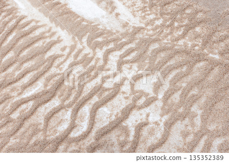 Frozen sand covered with white snow layer, beach ground texture, top view Frozen sand covered with white snow layer, beach ground texture, top view 135352389