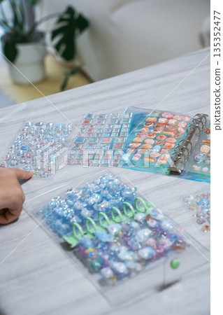 A girl putting 3D stickers into a sticker book 135352477