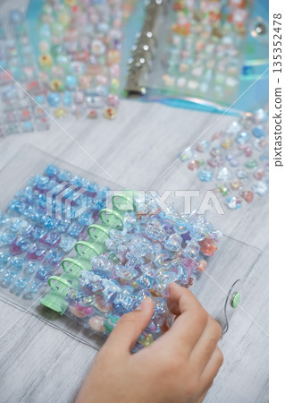 A girl putting 3D stickers into a sticker book 135352478