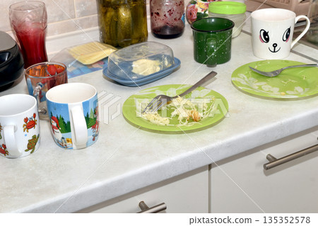 Dirty dishes are on the kitchen table. Dirty dishes are on the kitchen table. 135352578
