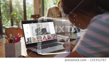 Girl writing in spiral notebook at wooden desk by window, with laptop, pencil holder, copy space Girl writing in spiral notebook at wooden desk by window, with laptop, pencil holder, copy space 135352767
