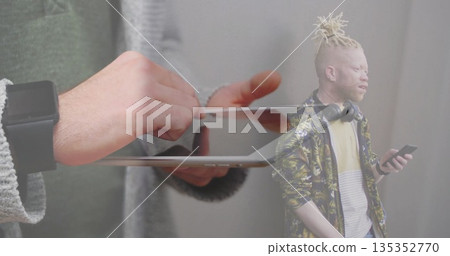 Tapping white male hands using tablet with smartwatch in studio, featuring smartphone, headphones Tapping white male hands using tablet with smartwatch in studio, featuring smartphone, headphones 135352770